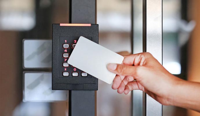 swiping a card on an access control reader with a keypad.