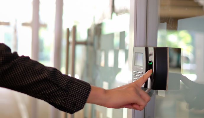 A person is using biometric fingerprint scanner door access control system to open the door