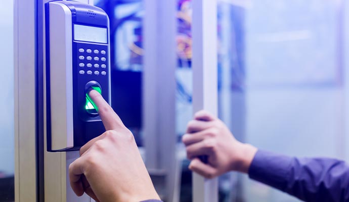 Person using a fingerprint scanner on a biometric access control device