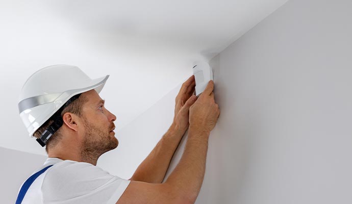 Person installing motion sensor with equipment