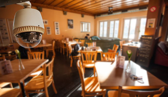 White dome camera overlooking the dining area of a restaurant