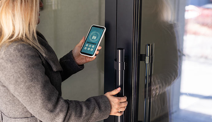 Woman unlocking glass door with phone
