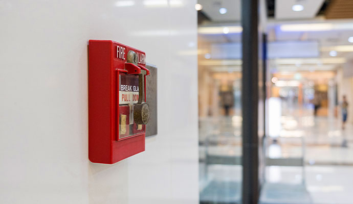 Commercial fire alarm pull station mounted in business hallway