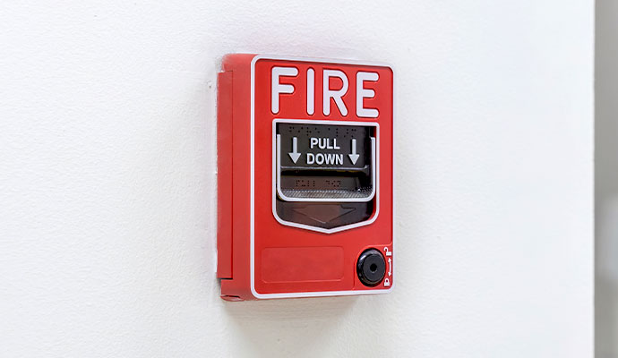 Red manual fire alarm pull station installed on a wall