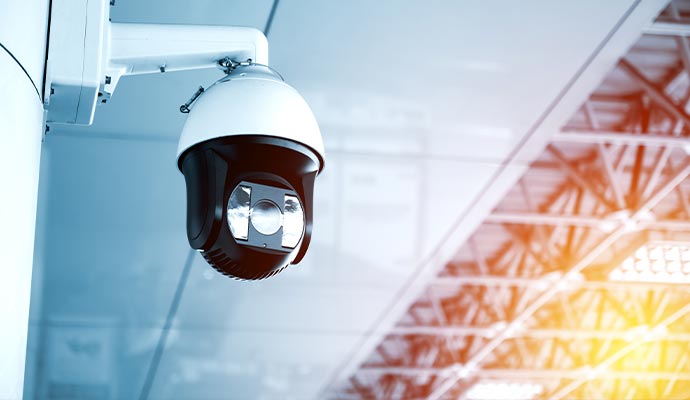 White and black PTZ dome security camera mounted in a large indoor facility