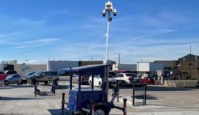 Mobile surveillance trailer with multiple security cameras monitoring parking lot