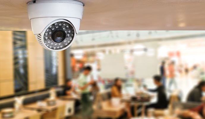 White dome camera monitoring indoor seating